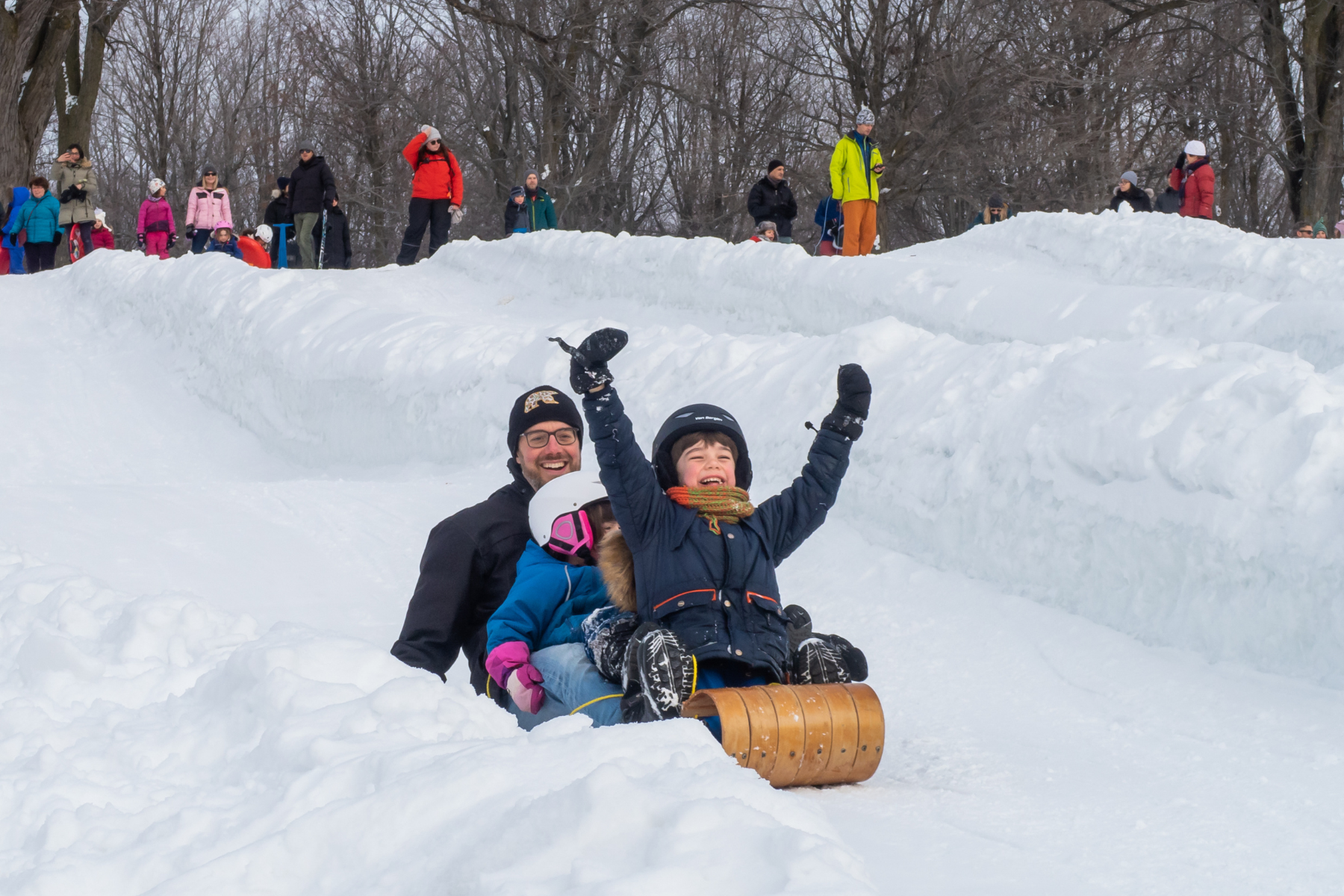 man and children having fun on a sledge at the mount Royal park